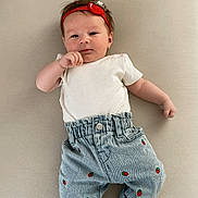 Elizabeth is registered to the contest to win money with this photo: baby, infant, headband, strawberry, jeans, white_shirt, socks, lying_down, cute, child, soft_surface, casual_clothing, small_hands, adorable, portrait, indoor, relaxed, fashion, baby_fashion, headwear