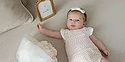 Elizabeth joined the competition — help win amazing prizes! baby, infant, girl, romper, headband, bow, flower_bouquet, couch, pillow, gold_frame, sign, 2_months, soft_lighting, indoors, portrait, cute, newborn, lying_down, pastel_colors, decor