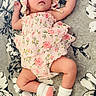 arms_raised, baby, blanket, bonnet, bottle, child, floral_blanket, floral_outfit, full_body, indoor, infant, lying_down, nursery, peaceful, pink_clothing, portrait, sleepy, socks, text_overlay, two_months_old