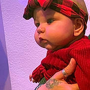 Ange a rejoint le concours — aidez-le/la à gagner de superbes lots ! baby, child, red_sweater, headband, tattoo, hand, skin, face, cheeks, blue_eyes, portrait, indoor, person, clothing, holding, expression, side_view, young_child, cute, infant