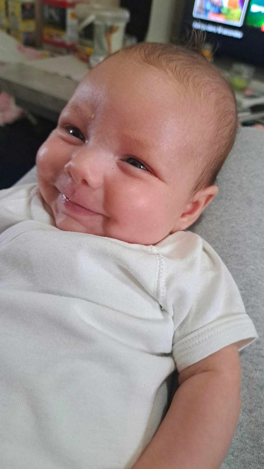 Ange participe au concours pour gagner de l'argent avec cette photo : baby, infant, smiling, white_clothing, close_up, face, skin, cute, young_child, portrait, indoor, person, head, expression, newborn, human, child, soft_light, baby_garment, cheek