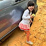 Brooklynne is registered to the contest to win money with this photo: apple, car, casual_clothing, child, daylight, dirt_ground, fruit, girl, happy, long_sleeve_shirt, nature, outdoor, patterned_leggings, pink_skirt, playful, reflection, smiling, sneakers, standing, vehicle