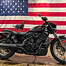 dog, motorcycle, harley_davidson, american_flag, pet_clothing, denim, black_motorcycle, indoor, floor, wheel, tire, handlebar, seat, small_dog, cute, animal, standing, patriotic, decor, background