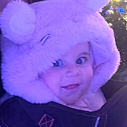 Ada is registered to the contest to win money with this photo: baby, child, hood, fluffy, purple_light, face, smile, eyes, cute, winter_clothing, portrait, indoors, person, babywearing, soft_texture, holiday_lights, closeup, warm, funny_hat, adorable