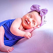Lilou participe au concours pour gagner de l'argent avec cette photo : baby, smiling, sleeping, purple, headband, bow, wrapped, newborn, infant, soft, cute, peaceful, resting, portrait, child, skin, feet, hand, cozy, fabric