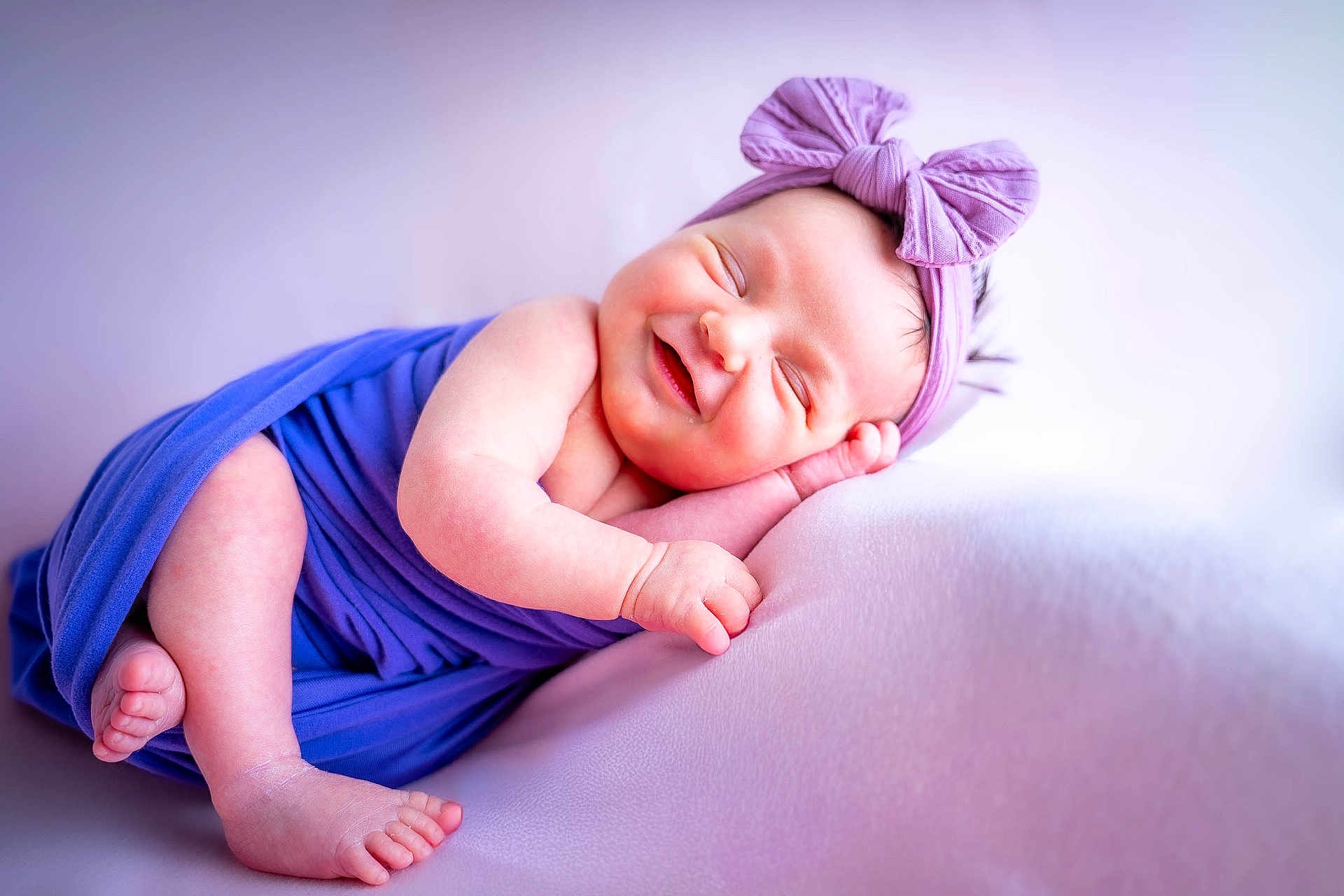Lilou participe au concours pour gagner de l'argent avec cette photo : baby, smiling, sleeping, purple, headband, bow, wrapped, newborn, infant, soft, cute, peaceful, resting, portrait, child, skin, feet, hand, cozy, fabric