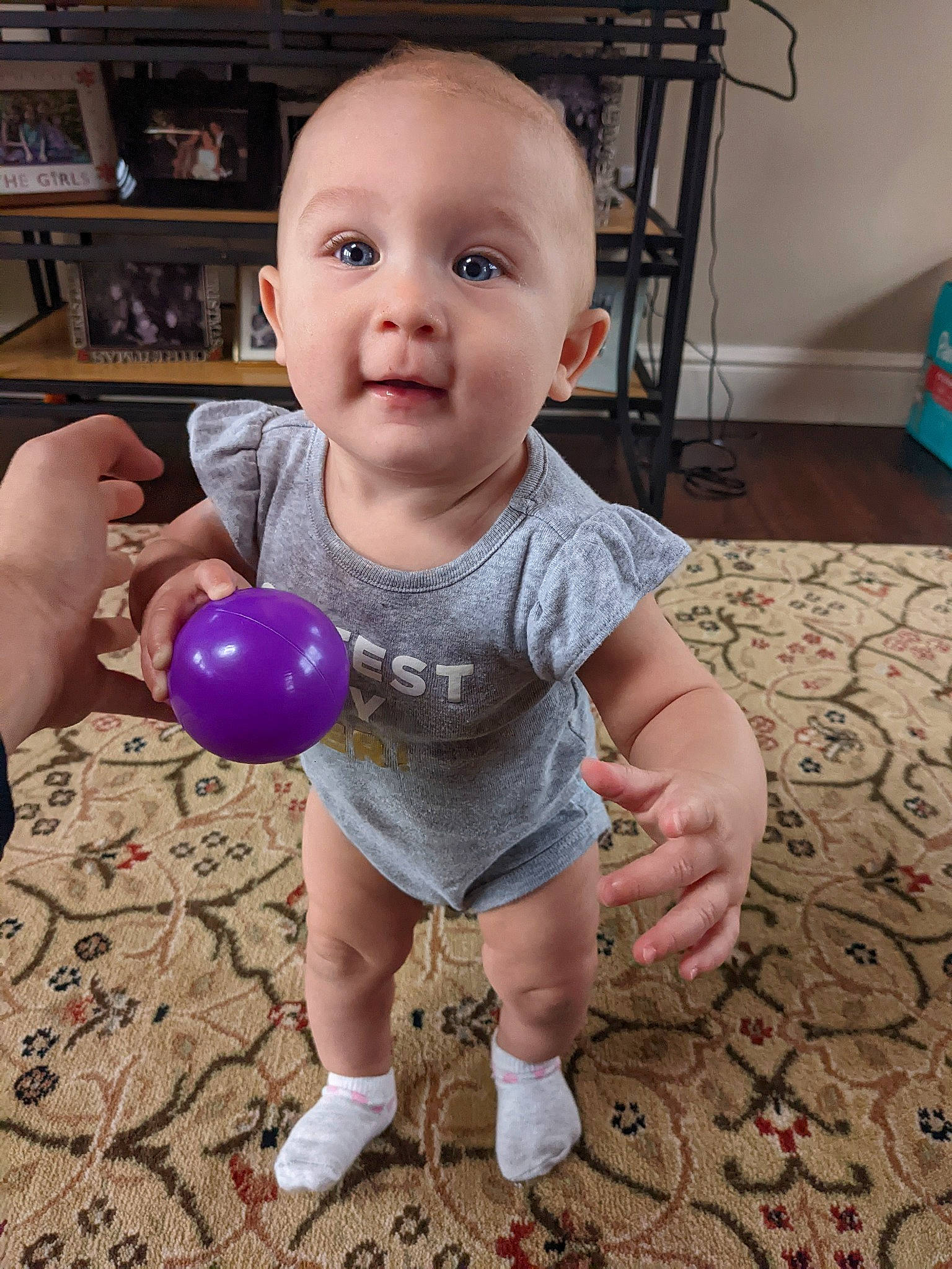Kenzie is registered to the contest to win money with this photo: baby, baby_toddler_clothing, balloon, cheek, child, finger, flooring, foot, fun, hand, happy, hardwood, party_supply, person, play, shelf, sitting, sleeve, toddler, water