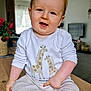 baby, barefoot, child, cozy, flowers, furniture, giraffe_print, happy, indoor, infant, living_room, long_sleeves, natural_light, pants, portrait, sitting, smiling, vase, white_shirt, wooden_table
