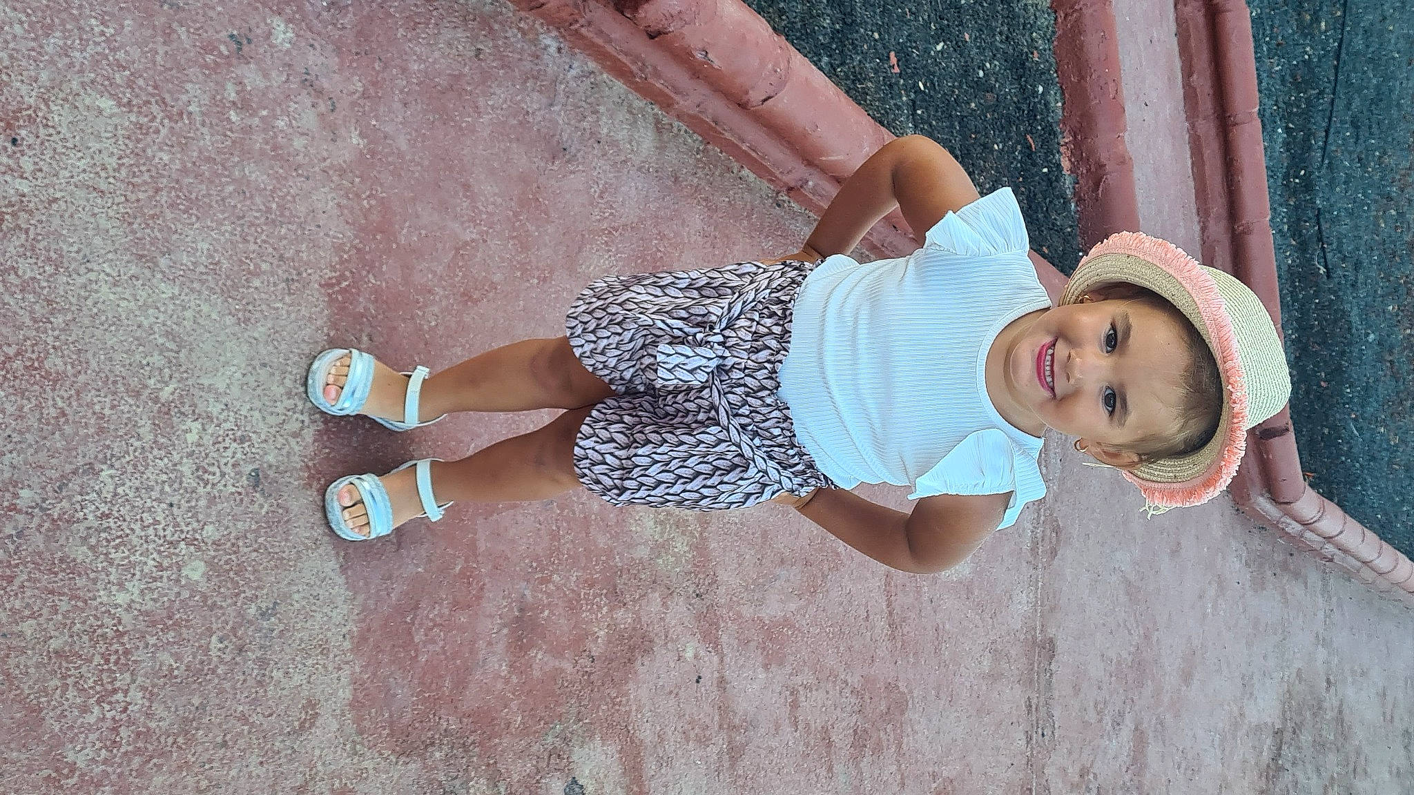 Maïwen participe au concours pour gagner de l'argent avec cette photo : baby_toddler_clothing, child, elbow, fedora, foot, fun, grass, happy, hat, headwear, human_leg, joint, joy, knee, pattern, person, pink, sun_hat, textile, thigh