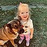 affection, animal, casual_clothing, child, cute, daylight, dog, friendship, garden, grass, happy, light_hair, nature, outdoor, pet, pink_shoes, playful, smiling, toddler, young_girl