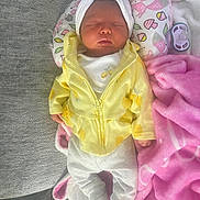 Leilani joined the competition — help win amazing prizes! baby, sleeping, infant, yellow_jacket, white_pants, headband, bow, blanket, pink_blanket, animal_print_pillow, pacifier, soft_toys, couch, cozy, resting, indoors, cute, peaceful, newborn, child