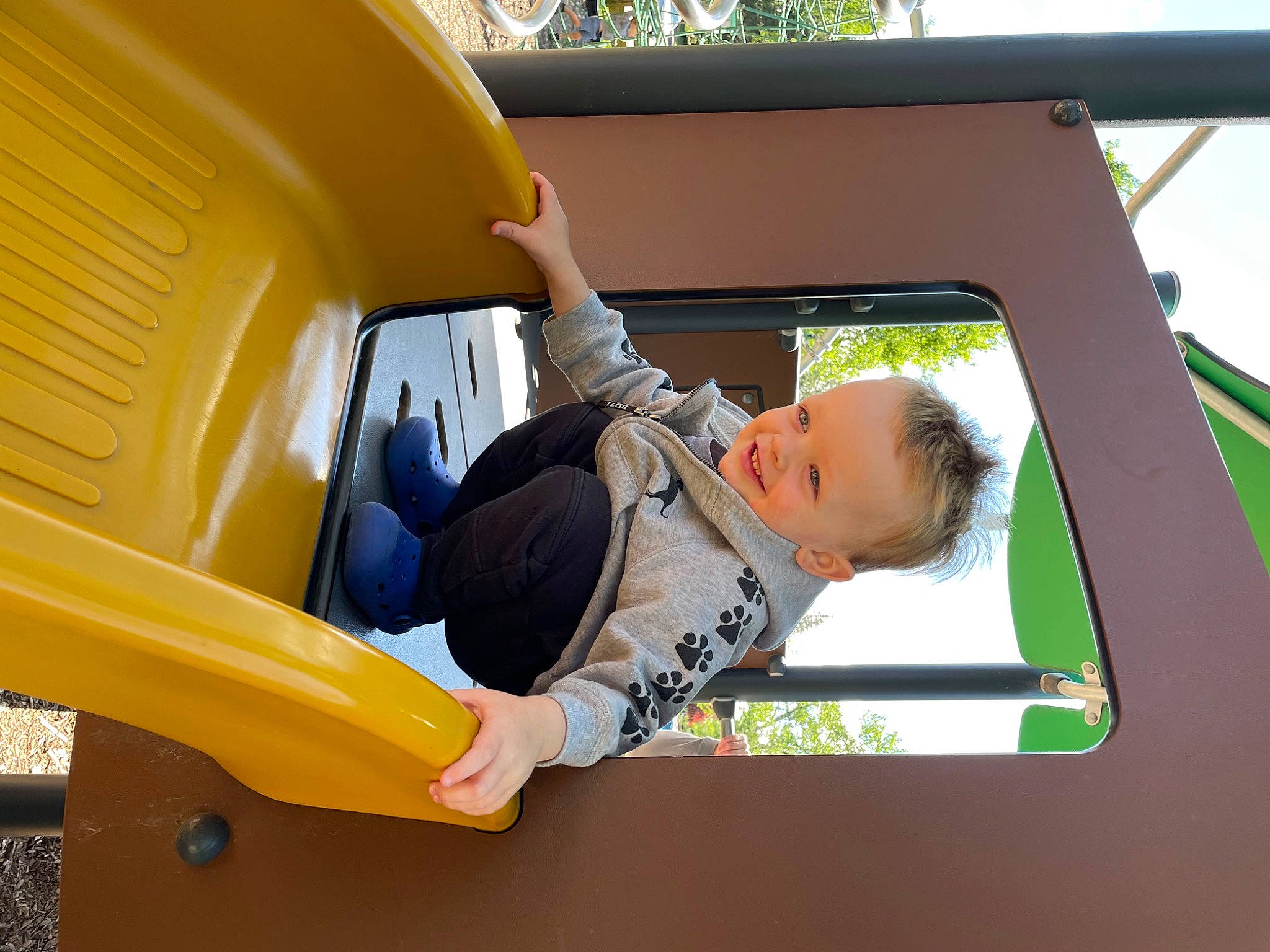 Maverick is registered to the contest to win money with this photo: auto_part, automotive_exterior, bumper, chute, fender, fun, grass, joy, leisure, motor_vehicle, outdoor_play_equipment, person, plant, play, playground, recreation, shade, toddler, tree, vehicle
