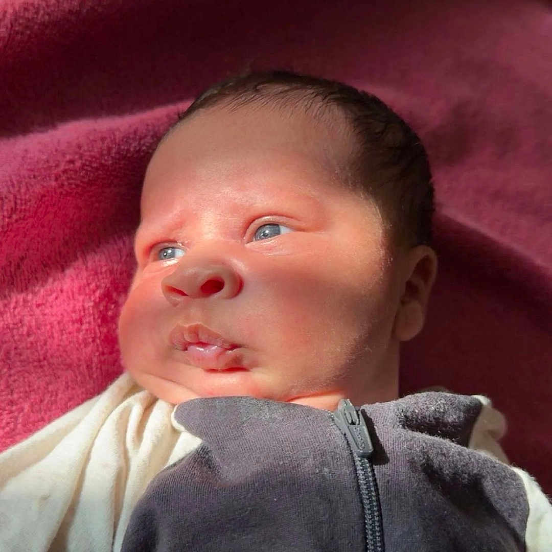 Kayden joined the competition — help win amazing prizes! baby, bed, blanket, clothing, coat, face, furniture, glove, happy, head, jacket, newborn, pants, person, photography, portrait, quilt, sleeping, smile, towel