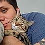 Tigee joined the competition — help win amazing prizes! animal, bed, blue_shirt, cat, close_up, comfort, cuddling, face, human, indoor, person, pet, pillow, portrait, relaxation, resting, snuggling, tabby_cat, tattoo, whiskers
