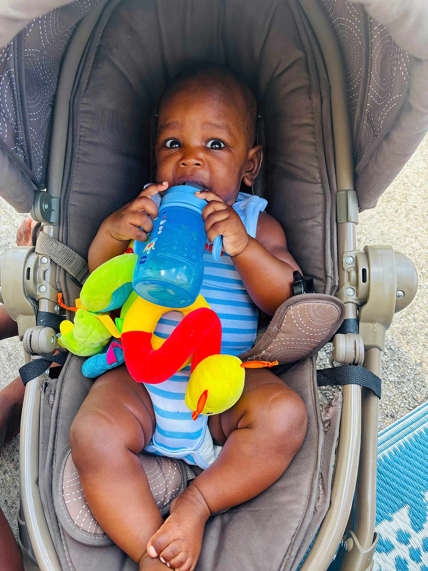 Elhadji a rejoint le concours — aidez-le/la à gagner de superbes lots ! baby, child, clothing, colorful, cute, expression, face, foot, hands, happy, infant, legs, outdoor, person, plush, seat, sippy_cup, striped, stroller, toy
