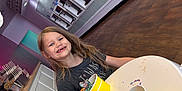 Bella joined the competition — help win amazing prizes! child, girl, ice_cream, frozen_yogurt, dessert, smiling, missing_teeth, yellow_cup, table, keys, keychain, spoon, pastel_colors, indoor, floor, frozen_yogurt_machine, counter, happy, long_hair, casual_clothing