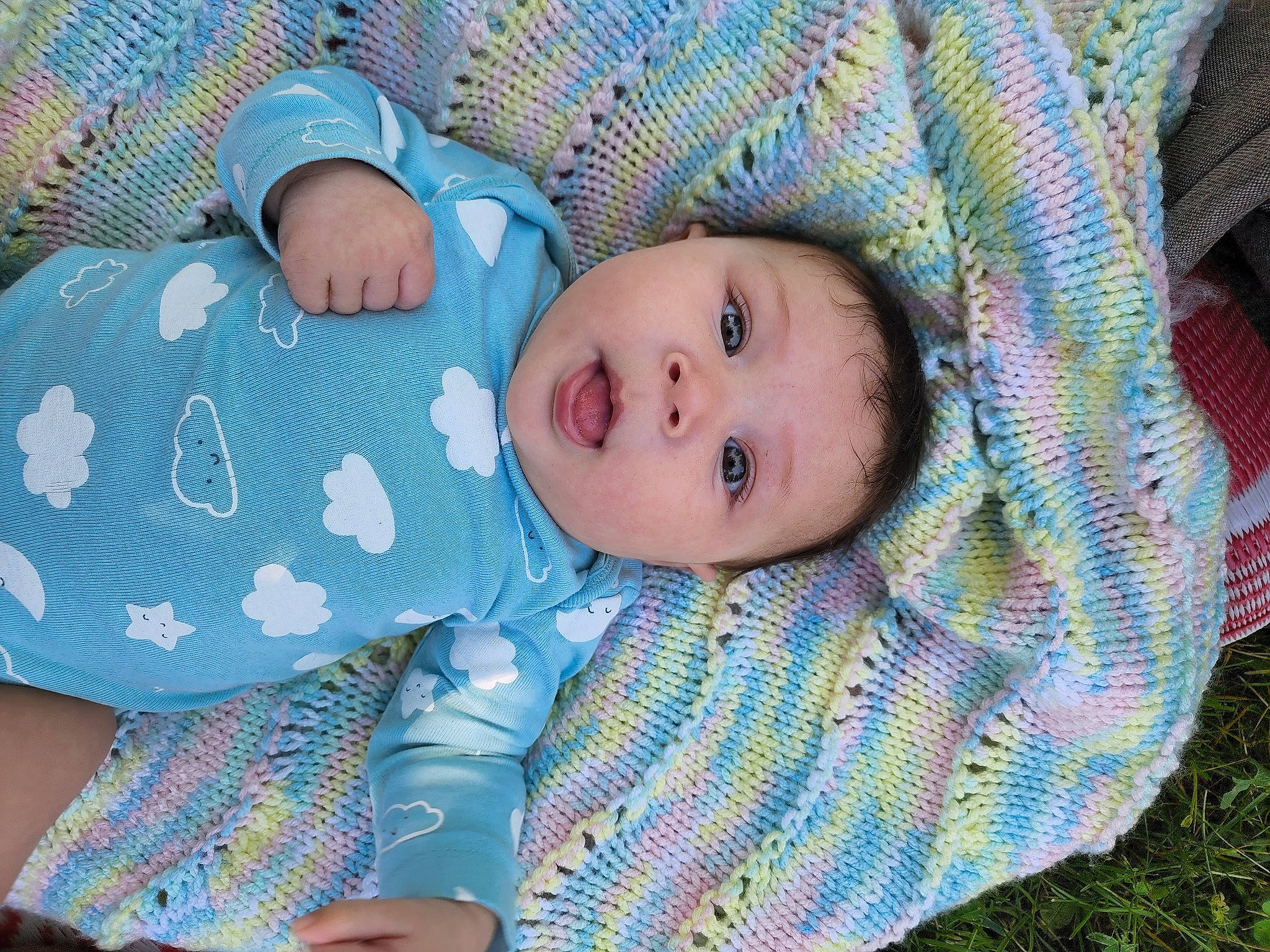 Angela is registered to the contest to win money with this photo: azure, baby, baby_products, baby_toddler_clothing, blue, cheek, child, comfort, electric_blue, grass, iris, linens, pattern, person, sitting, skin, sleeve, textile, toddler