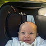 Pauline participe au concours pour gagner de l'argent avec cette photo : baby, smiling, car_seat, white_clothing, blanket, outdoor, sunlight, park_bench, greenery, face, infant, cute, portrait, child, seatbelt, warm_clothing, happy, head, person, nature