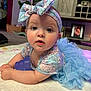 baby, infant, blue_outfit, headband, bow, toy, indoor, carpet, plant, furniture, picture_frame, curtains, face, eyes, expression, toddler, child, person, cute, soft_lighting