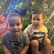 Ethan joined the competition — help win amazing prizes! child, children, boy, smiling, tongue_out, hoodie, tshirt, christmas_lights, holiday, festive, outdoor, night, greenery, decorations, expression, candid, happy, sitting, cute, playful