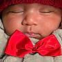 Rayaan joined the competition — help win amazing prizes! baby, sleeping, red_hat, red_bow, blanket, cozy, closeup, face, cute, infant, soft_texture, warm_clothing, adorable, peaceful, child, portrait, indoor, resting, toddler, knitted