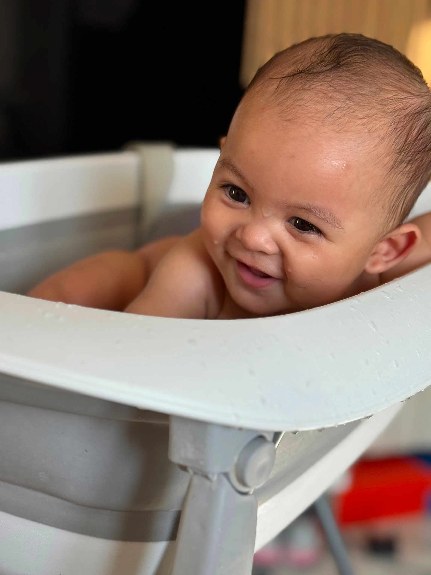 Isaac a rejoint le concours — aidez-le/la à gagner de superbes lots ! baby, smile, water, bathtub, indoor, child, face, happy, skin, head, hair, droplets, bath, toddler, person, closeup, expression, light, seat, joy