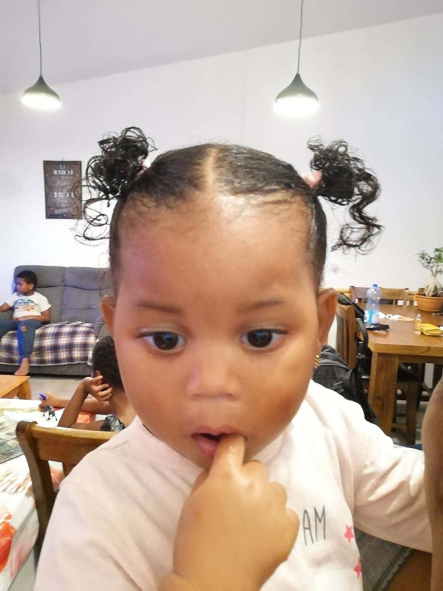 Inayah participe au concours pour gagner de l'argent avec cette photo : baby, black_hair, chair, cheek, ear, eyebrow, eyelash, forehead, gesture, hair, hairstyle, happy, head, houseplant, lamp, lip, nose, person, t_shirt, table