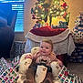 Anslee is registered to the contest to win money with this photo: baby, child, christmas_tree, presents, gift_wrap, indoor, holiday, festive, smiling, infant, chair, carpet, decorations, lights, sweater, teddy_bear_pattern, stockings, window, furniture, celebration