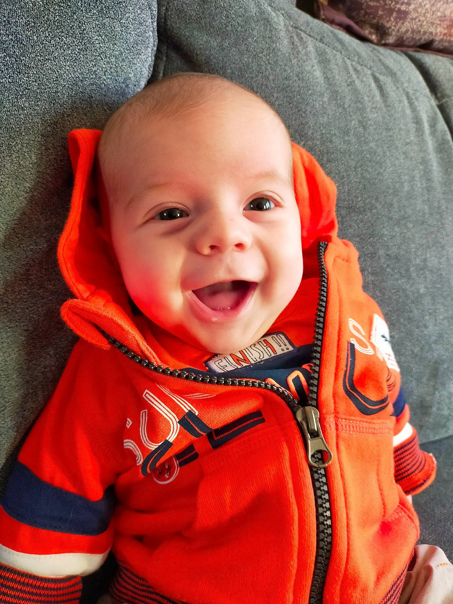 Tiago participe au concours pour gagner de l'argent avec cette photo : baby, baby_toddler_clothing, cheek, collar, comfort, cool, eye, eyebrow, face, happy, head, iris, nose, orange, person, product, red, sleeve, smile, toddler