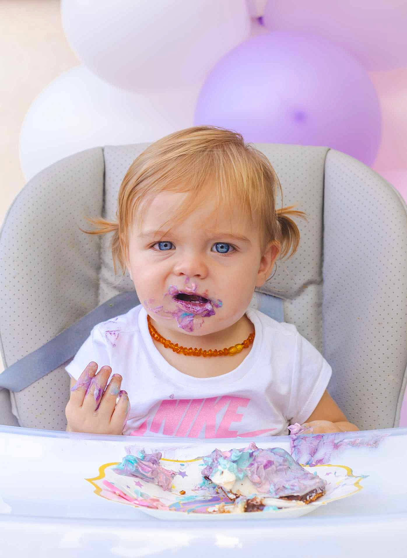 Lina a rejoint le concours — aidez-le/la à gagner de superbes lots ! baby, baby_toddler_clothing, balloon, birthday, blond, chair, cheek, child, event, facial_expression, fun, happy, iris, party_supply, person, pink, sitting, sweetness, table, toddler