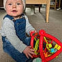 Ethan is registered to the contest to win money with this photo: baby, cap, clothing, couch, face, furniture, hardwood, hat, head, indoors, interiordesign, jeans, pants, person, photography, portrait, rattle, sitting, toy, wood