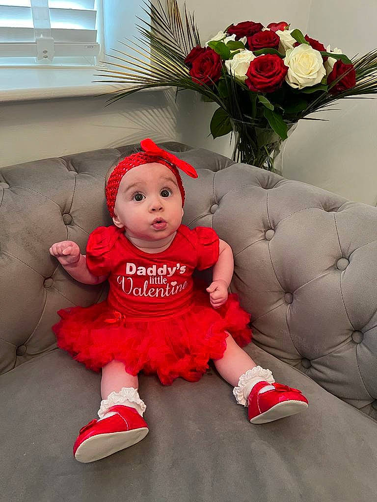 Ivy-mae is registered to the contest to win money with this photo: baby, baby_toddler_clothing, child, event, flooring, flower, flower_arranging, grass, hat, headwear, holiday, leg, person, pink, plant, red, rose, sock, surprise, toddler