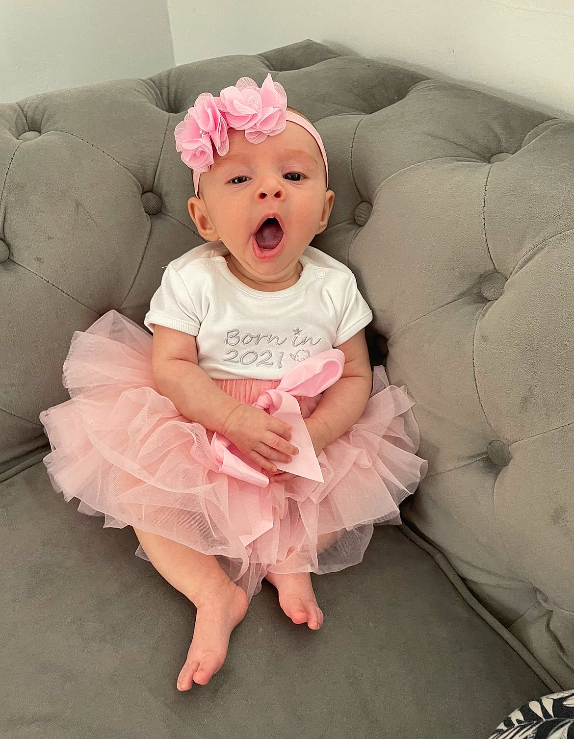 Ivy-mae is registered to the contest to win money with this photo: arm, baby, baby_toddler_clothing, child, comfort, day_dress, embellishment, face, fashion_accessory, flash_photography, happy, headband, human_body, iris, person, petal, pink, skin, sleeve, surprise