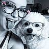 bow, companion, cute, dog, eyewear, face, glasses, hair_bun, happy, human, indoor, pet, playful, portrait, selfie, smiling, tank_top, tongue_out, white_dog, woman