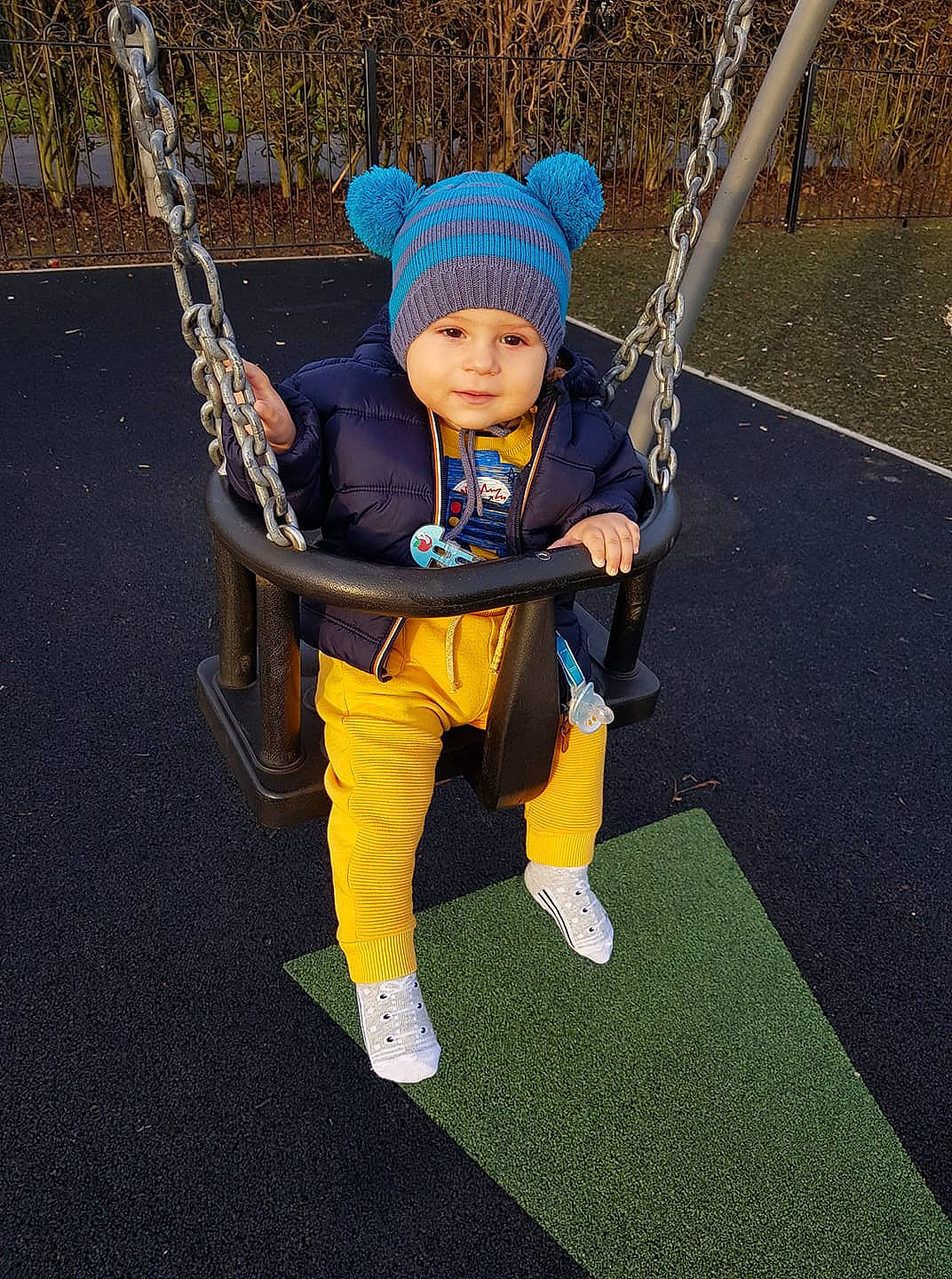 Eduard is registered to the contest to win money with this photo: child, fun, outdoor_play_equipment, person, plant, playground, public_space, smile, swing, toddler