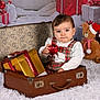 Isaac a rejoint le concours — aidez-le/la à gagner de superbes lots ! baby, child, suitcase, christmas, holiday, ornament, gift_box, plaid_clothing, teddy_bear, santa_hat, white_rug, festive, indoor, cute, portrait, decorations, present, fluffy, seasonal, smiling