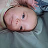 Jojo is registered to the contest to win money with this photo: baby, infant, child, portrait, lying_down, blanket, gray_blanket, soft_surface, close_up, face, eyes, curious, awake, clothing, onesie, hand, indoor, home, adorable, photography