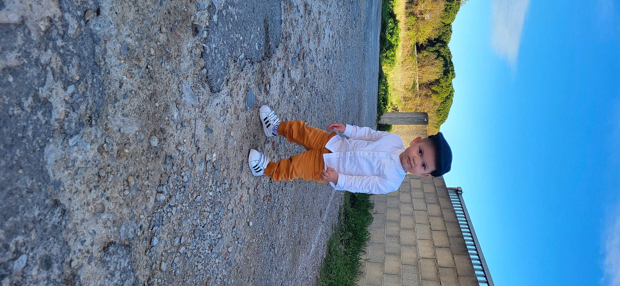 Kelyo participe au concours pour gagner de l'argent avec cette photo : asphalt, azure, blue, child, concrete, fun, headwear, landscape, leisure, people_in_nature, person, plant, road_surface, rock, shadow, sidewalk, sky, soil, toddler, tree