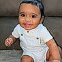 baby, smiling, child, infant, cute, happy, face, eyes, clothing, white_outfit, buttons, sitting, soft_surface, indoors, portrait, skin, hand, legs, young, person