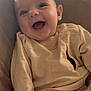 baby, smiling, couch, clothing, infant, happy, face, child, indoor, person, sitting, cute, cozy, apparel, relaxed, young, portrait, skin, furniture, small