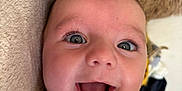 Ollie joined the competition — help win amazing prizes! apparel, baby, blanket, child, close_up, cute, expression, eyes, face, happy, head, indoors, infant, joy, lying_down, mouth, person, skin, smiling, soft