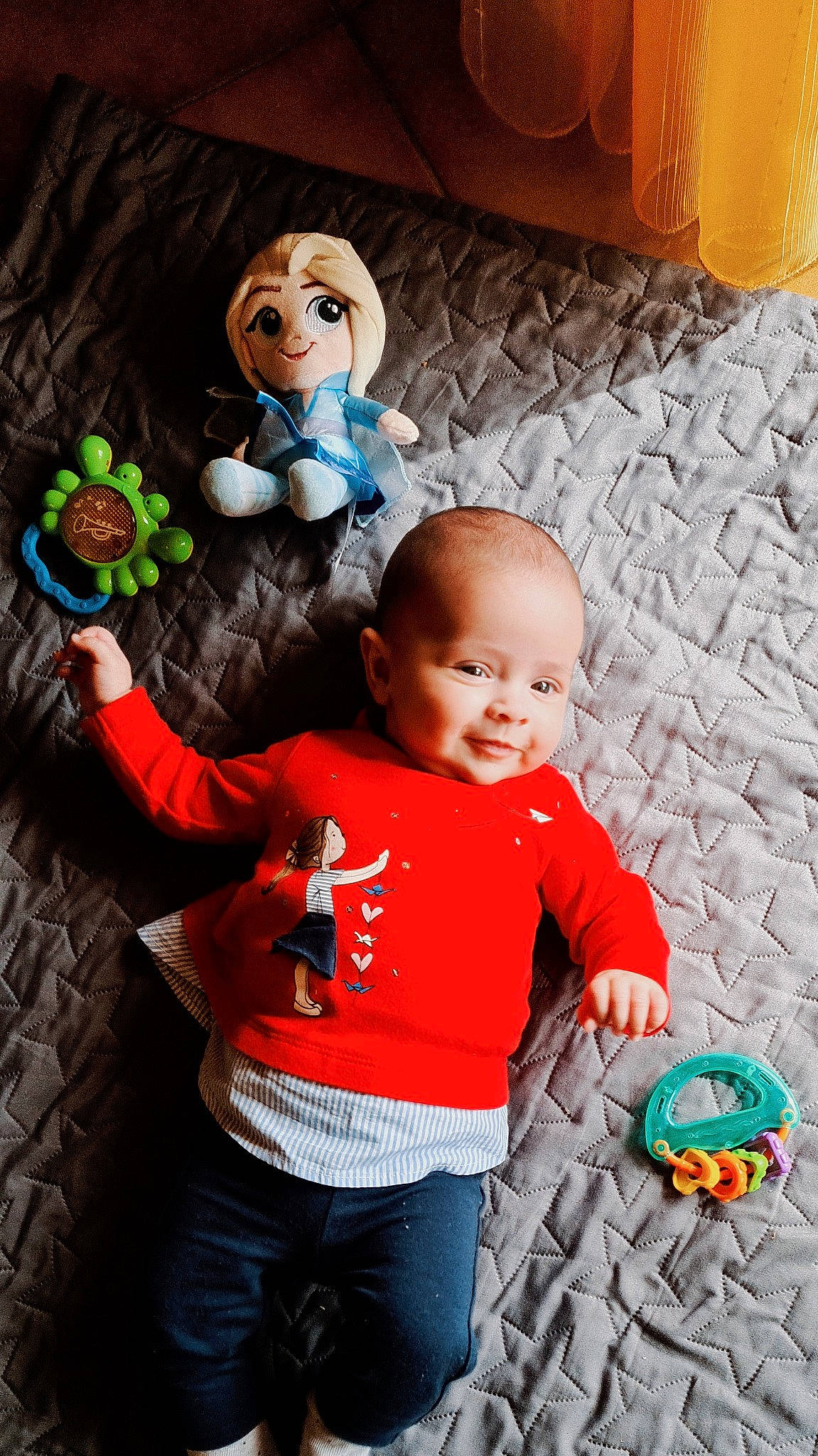 Alice participe au concours pour gagner de l'argent avec cette photo : automotive_tire, baby_toddler_clothing, child, facial_expression, fun, green, happy, orange, organ, people, person, photograph, product, smile, standing, textile, tire, toddler, toy, wood