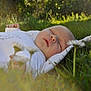 baby, blanket, closeup, daisy, face, flower, grass, greenery, infant, nature, outdoor, peaceful, portrait, relaxation, resting, serene, sleeping, soft, sunlight, young_child