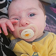 Elyo participe au concours pour gagner de l'argent avec cette photo : baby, pacifier, yellow_outfit, close_up, infant, hand, face, eyes, skin, comfort, soft, indoor, person, child, resting, cute, young, portrait, expression, clothing