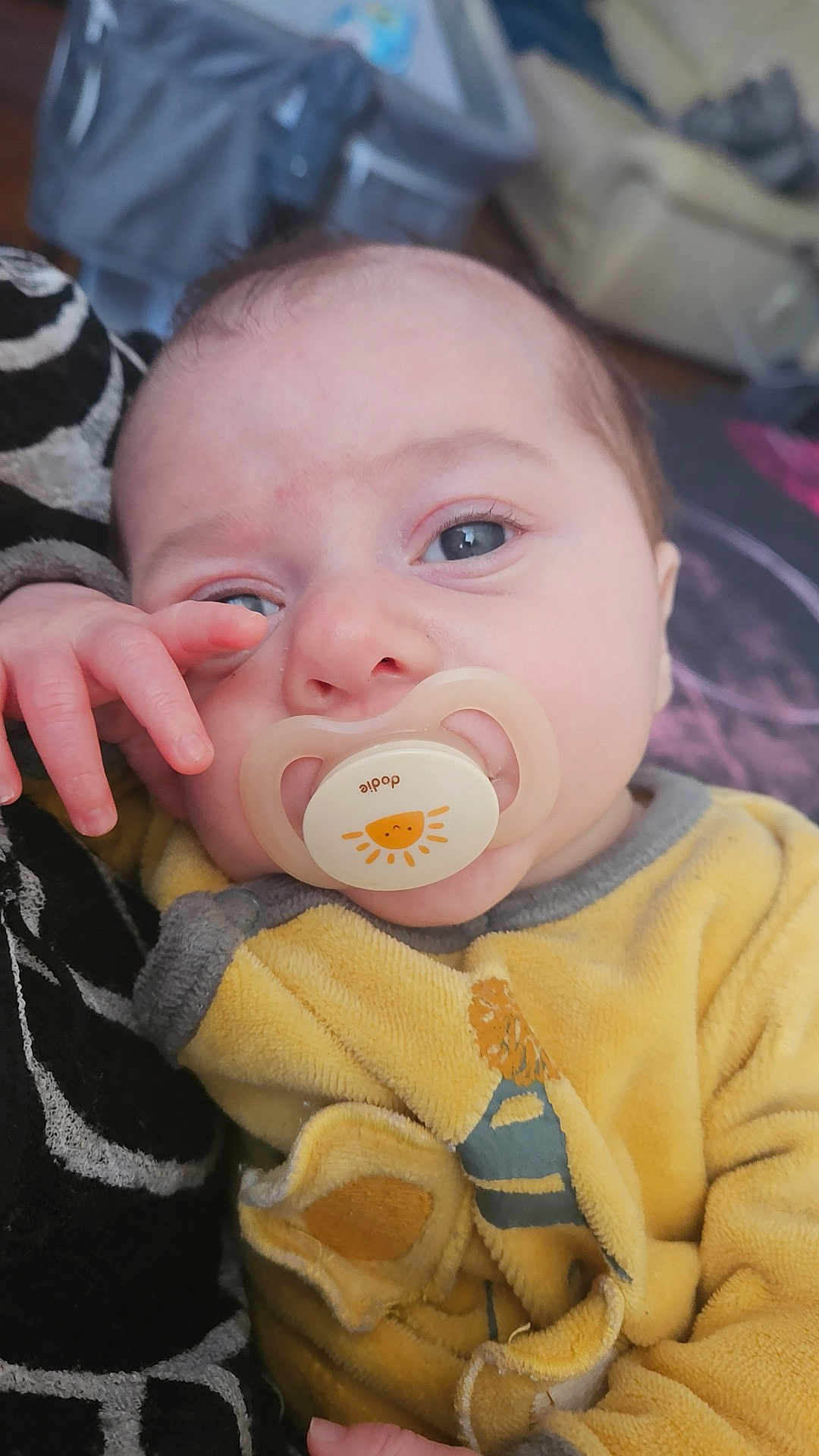 Elyo participe au concours pour gagner de l'argent avec cette photo : baby, pacifier, yellow_outfit, close_up, infant, hand, face, eyes, skin, comfort, soft, indoor, person, child, resting, cute, young, portrait, expression, clothing