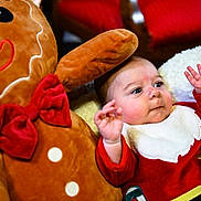 Elyo participe au concours pour gagner de l'argent avec cette photo : baby, cheeks, child, cozy, cushion, cute, face, festive, gingerbread_man, hands_up, holiday, indoors, plush_toy, red_bow, red_outfit, sitting, smiling, soft_texture, toy, white_collar