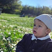 Isaac participe au concours pour gagner de l'argent avec cette photo : toddler, child, outdoor, grass, flowers, beanie, jacket, sunlight, nature, park, curious, sitting, daytime, greenery, portrait, young_child, casual_clothing, expression, person, scenic