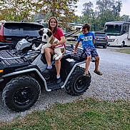 Cressyn Lilly is registered to the contest to win money with this photo: atv, camper, campground, casual_clothing, child, dog, footwear, grass, gravel, happy, jeep, nature, outdoor, person, pet, recreation, smile, toyota, tree, vehicle