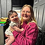 Selah is registered to the contest to win money with this photo: baby, book, box, casual, chair, child, clothing, face, furniture, glasses, hair, happy, holding, indoor, person, portrait, skin, smile, sweater, woman