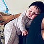 baby, sleeping, pajamas, bear_pattern, child, infant, closeup, cuddling, hand, black_clothing, indoor, window_blinds, peaceful, portrait, soft_light, cozy, resting, person, cute, nap